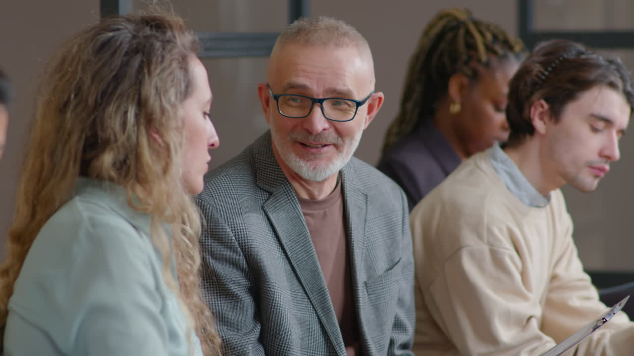 Senior Man and Young Woman Chatting before Job Interview