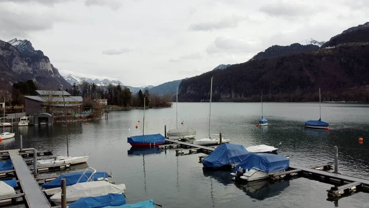 Aerial viewpoint at the harbour in Weesen with some boats in the lake Walensee in St. Gallen, Switzerland.