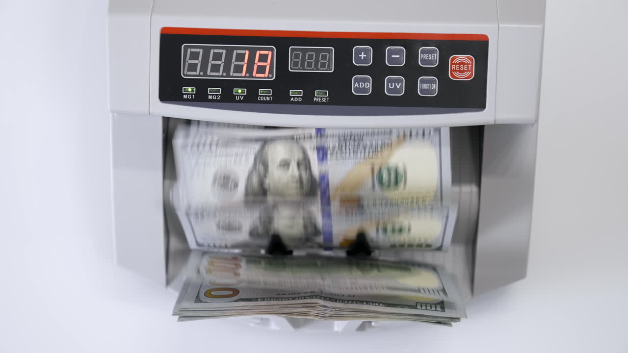 Money counting machine with 100 dollar banknotes. US national paper currency. Bank automatic equipment for calculation paper currency, finance concept