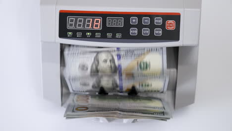 money counting machine with 100 dollar banknotes. us national paper currency. bank automatic equipment for calculation paper currency, finance concept