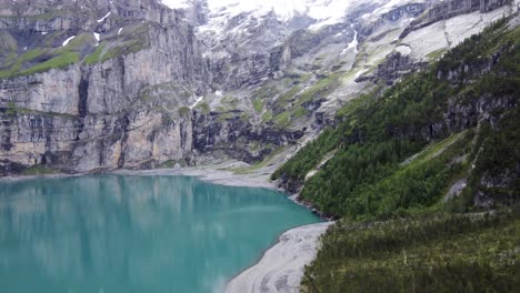 swiss alpine oeschinen lake with its turquoise blue water amid bluemlisalp alps mountains in kandersteg, switzerland