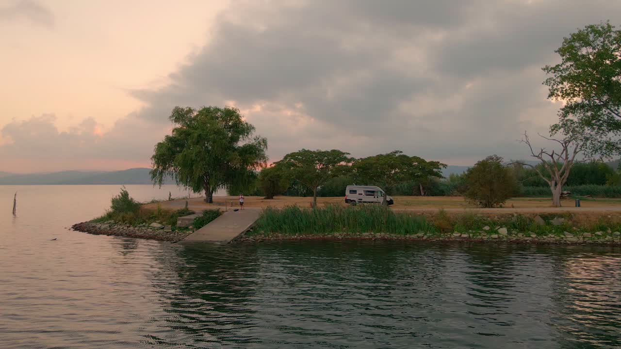 paisaje tranquilo junto al lago trasimeno durante el amanecer en italia - toma aérea de drones