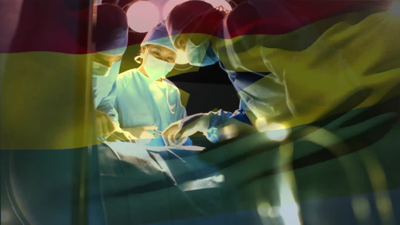 Animation of flag of ghana waving over surgeons in operating theatre
