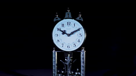 close up of an old clock in low key studio lighting, backward dolly