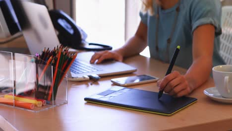 female executive working over graphic tablet at her desk 4k