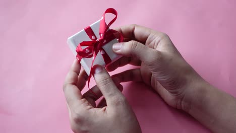 manos sosteniendo una pequeña caja de regalos