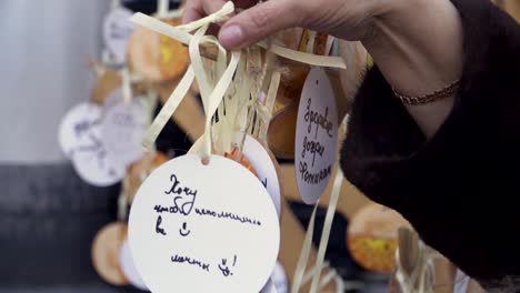 hand holding a tag from a string of wooden decorations