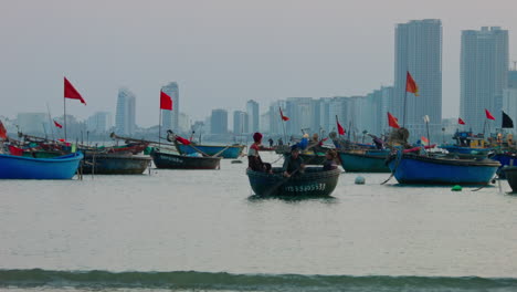 static shot of fishermen paddling in a small traditional boat in da nang beach