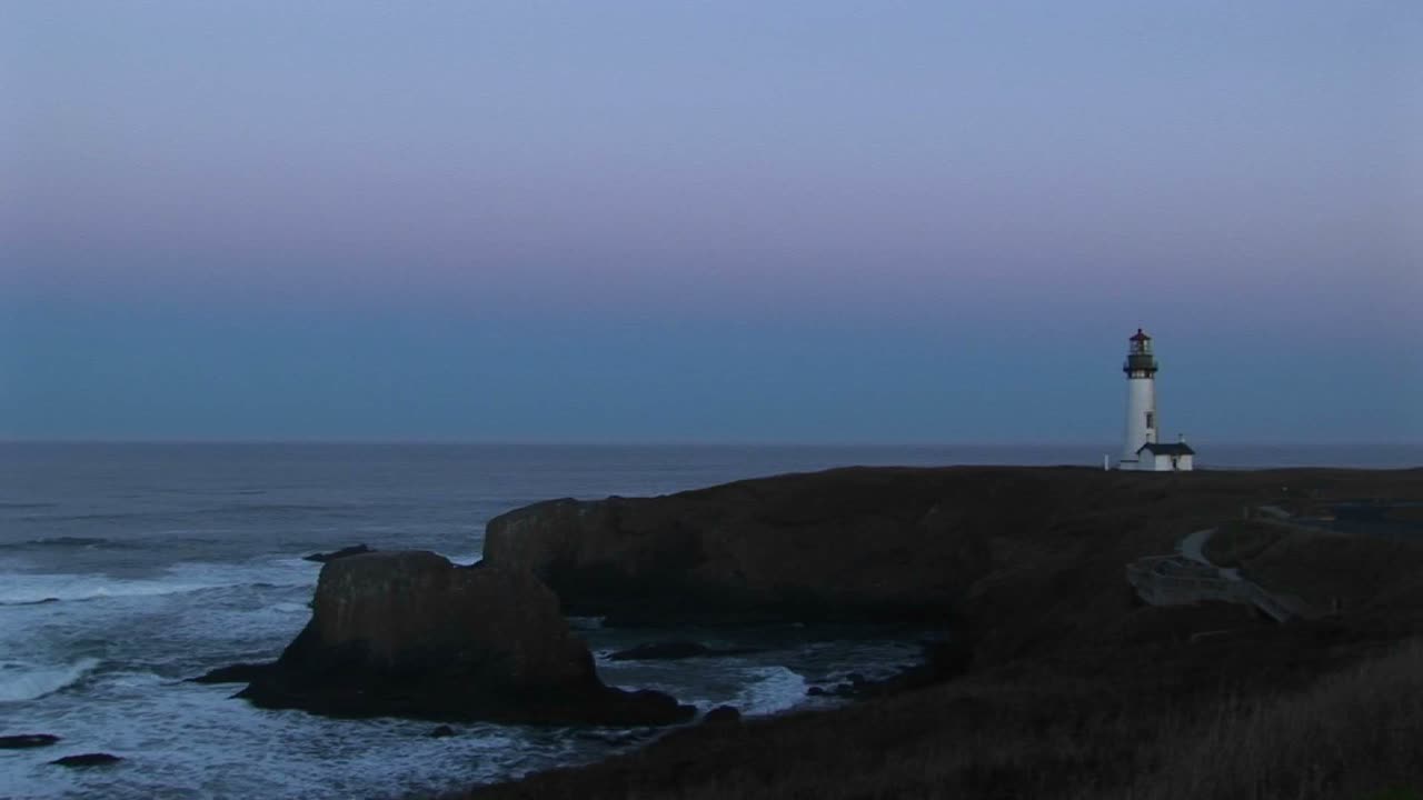 외로운 등대가 조용한 바다가 내려다보이는 바위 지대를 지키고 있습니다.