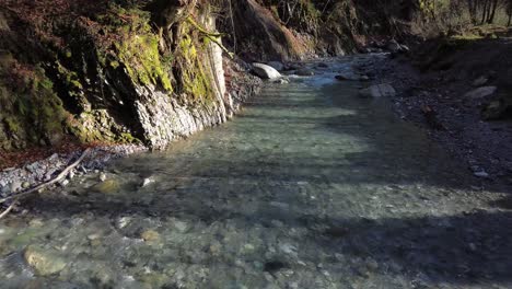 disparo de drone de un hermoso río de montaña con acantilados y árboles a su lado