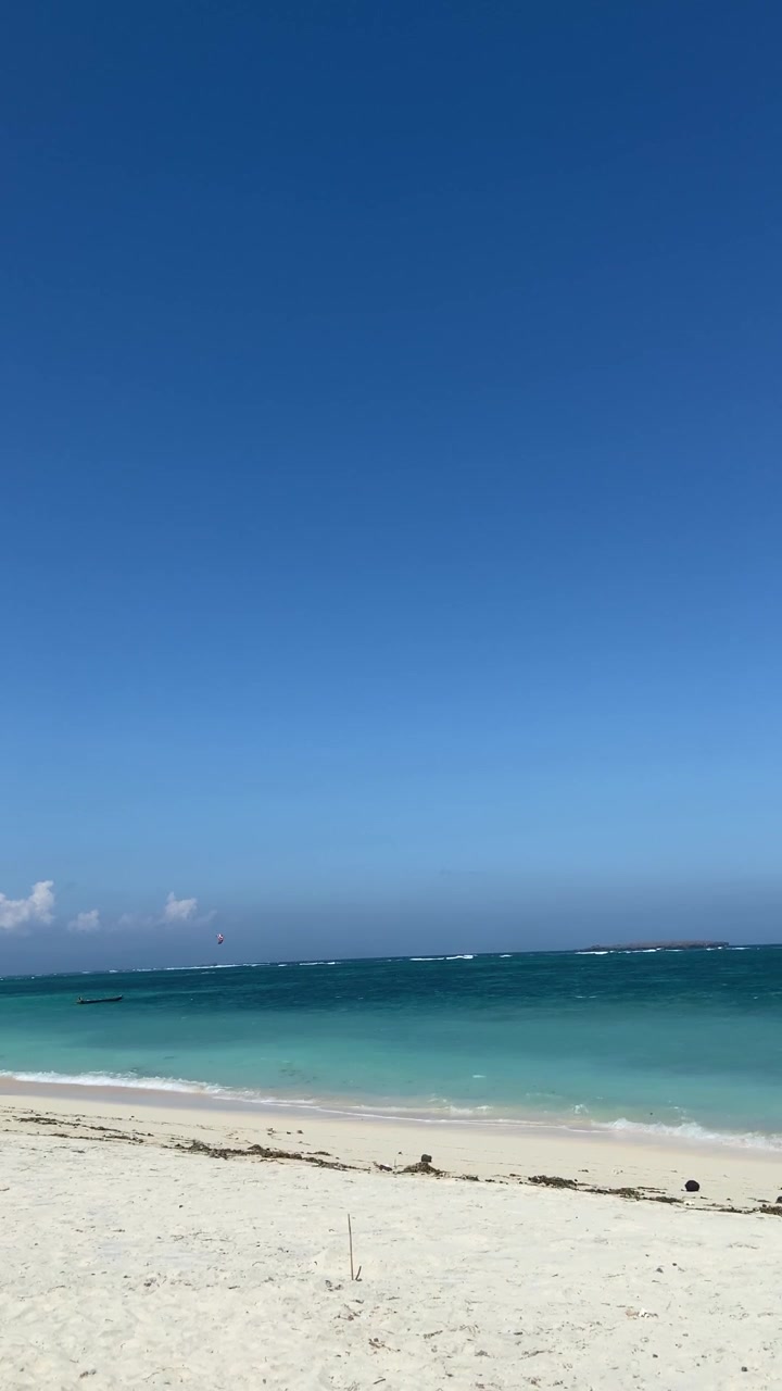 Spiaggia tropicale con acqua turchese e cielo azzurro limpido.