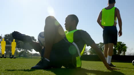 practicing ball control, soccer player wearing bright vest on sunny field