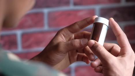persona que sostiene un pequeño frasco de medicamento