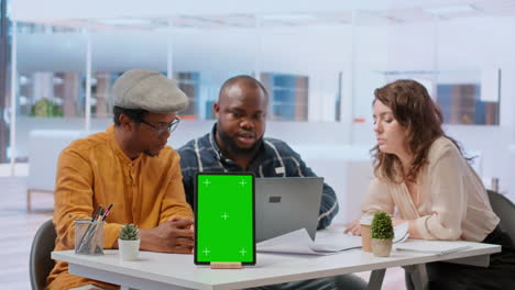 People-discussing-with-the-salesman-next-to-chroma-key-screen-on-tablet