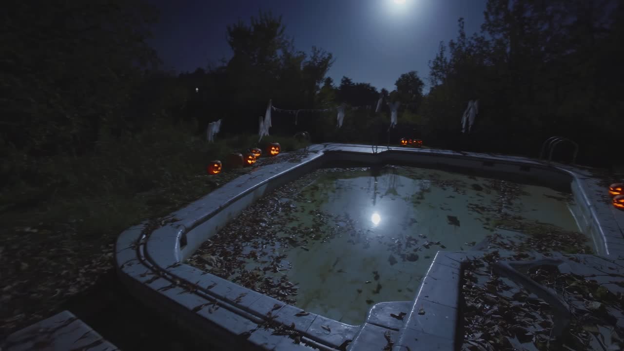 Eerie nighttime scene of an abandoned pool surrounded by glowing jack-o'-lanterns and ghostly decorations, capturing the haunting atmosphere of a forgotten Halloween celebration