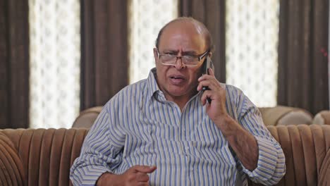 Angry-Indian-old-man-talking-to-someone-on-phone