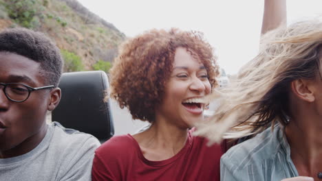 grupo de jóvenes amigos en la parte trasera de un coche de alquiler de techo abierto en vacaciones de verano