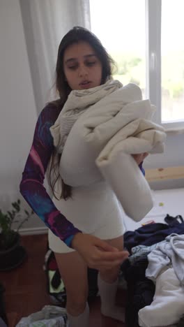 woman making bed and organizing clothes