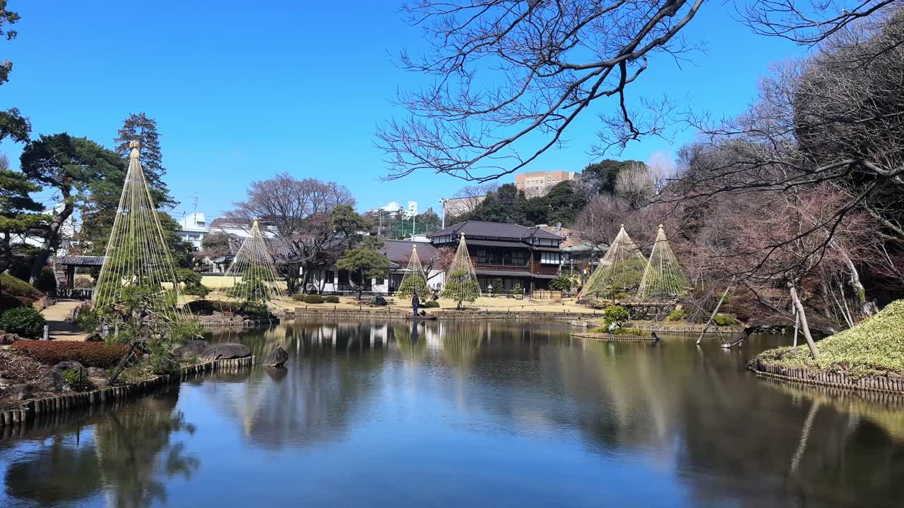 A peaceful Japanese garden with scenic views of a pond, trees, and traditional architecture