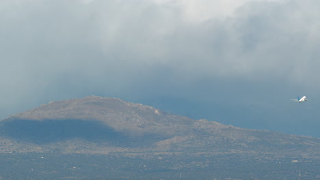 Plane-ascending-to-cloudy-sky-and-flying-over-mountains