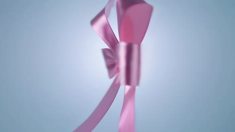 elegant pink satin bow with glowing center on a gradient background