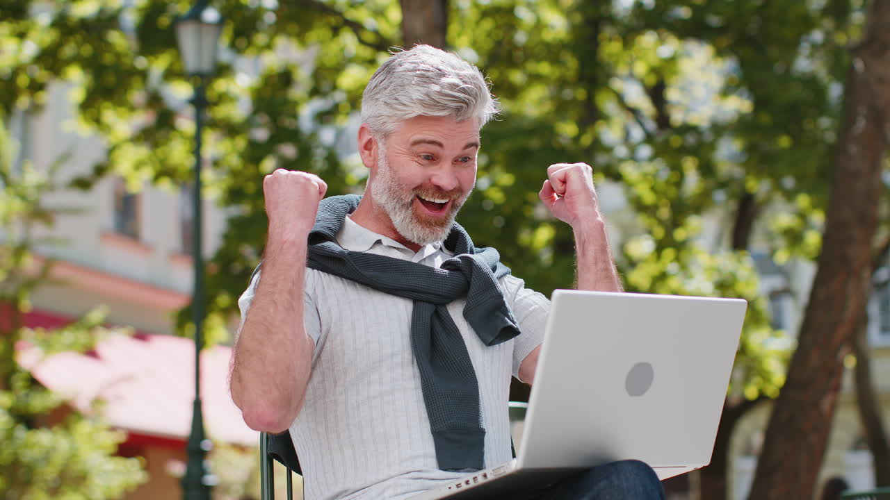 Middleaged man use laptop computer celebrating win good message news lottery jackpot casino victory