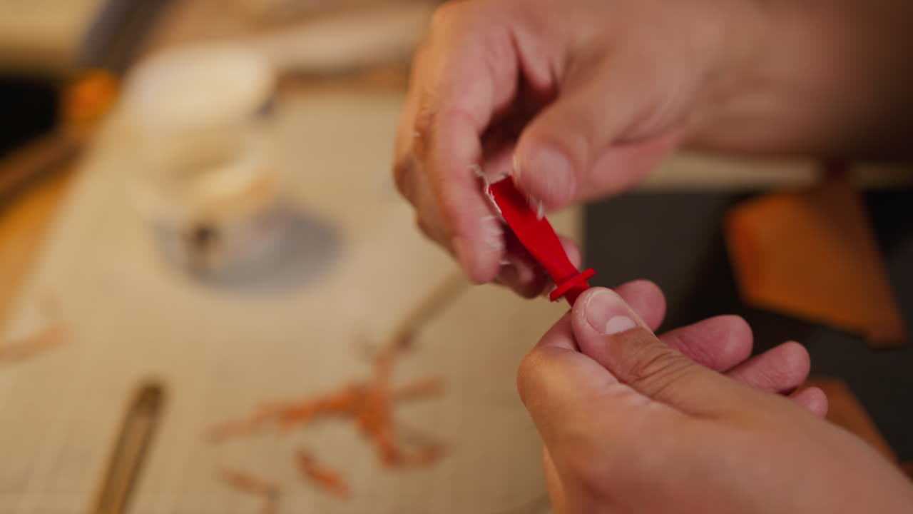 trabajador limpia un cepillo de plástico de restos de pegamento en el lugar de trabajo