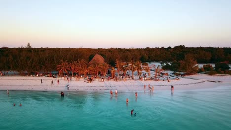 curva panorámica más tranquila vuelo teledirigido disparado en el bar de la playa al atardecer de la hora dorada