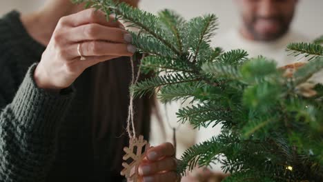 Happy couple decorating Christmas tree at home.
