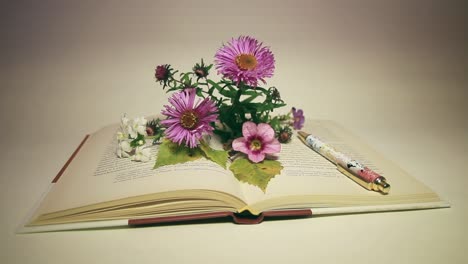 primer plano de flores y pluma en el libro