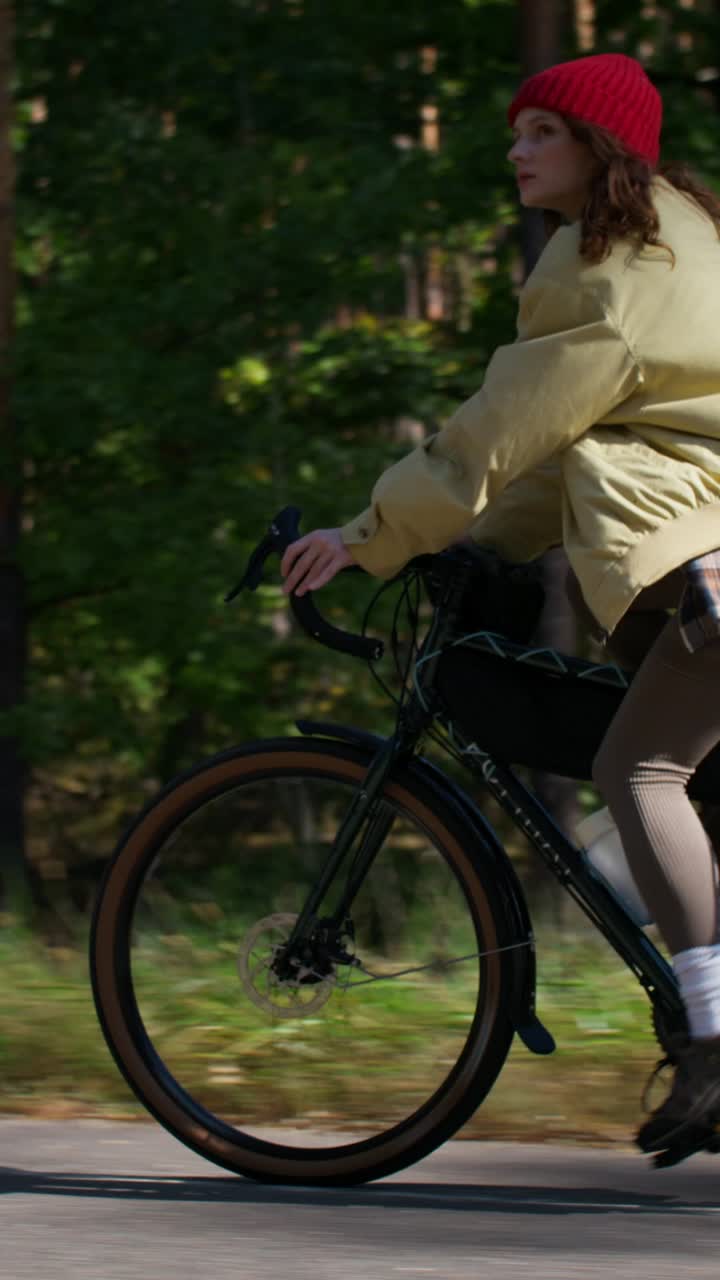 Woman cycling through a forest path