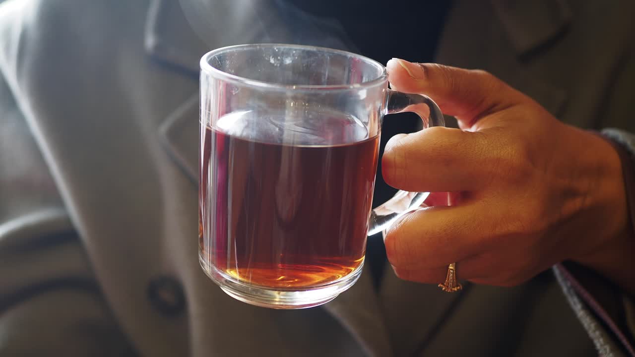 차 한 잔 을 들고 있는 손 의 클로즈업