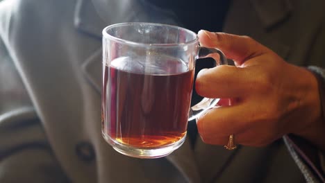 primer plano de una mano sosteniendo una taza de té