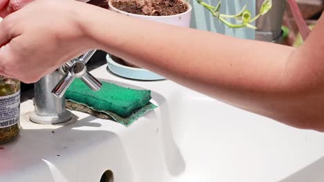 a person washes hands with soap at an outdoor sink, focusing on hygiene and cleanliness.