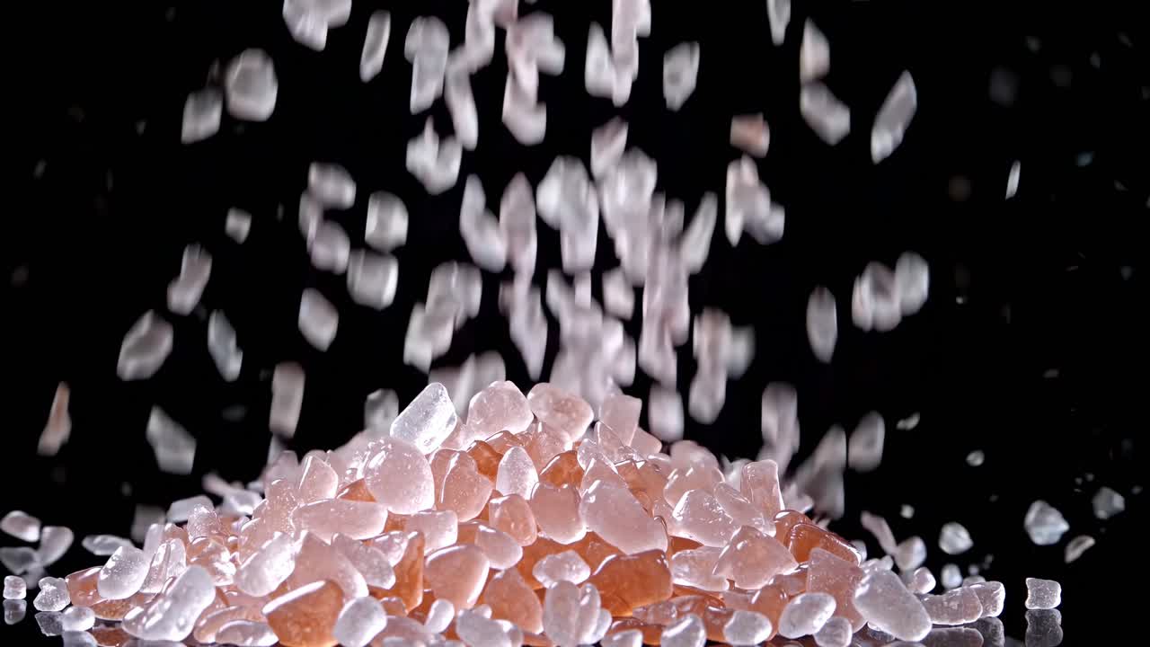 Pink and Clear Crystals Falling on Black Background