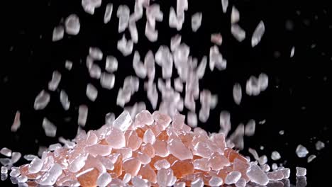 pink and clear crystals falling on black background