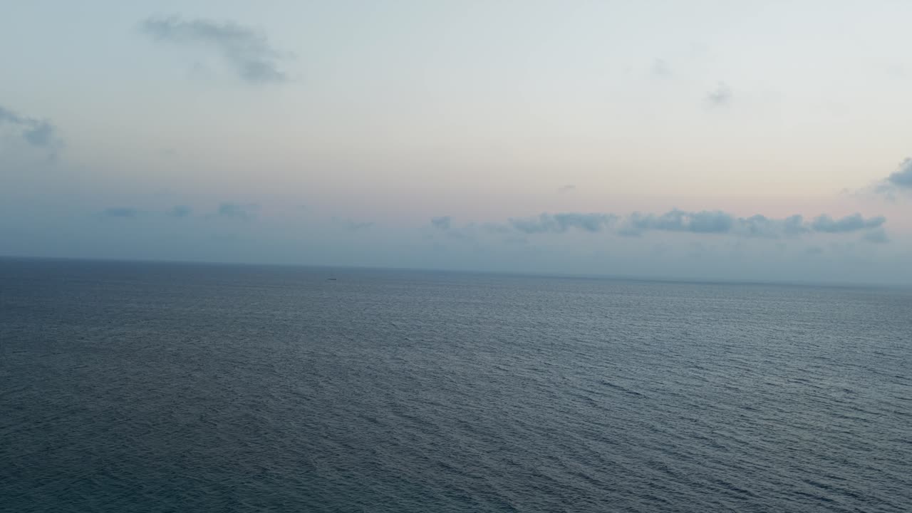 Adriatic Sea at sunrise, colorful twilight sky over calm water. Aerial forward, copy space