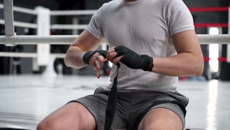 strong athlete man wrap his hands before boxing