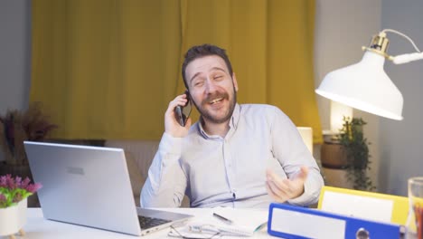 trabajador de oficina en casa hablando por teléfono felizmente.