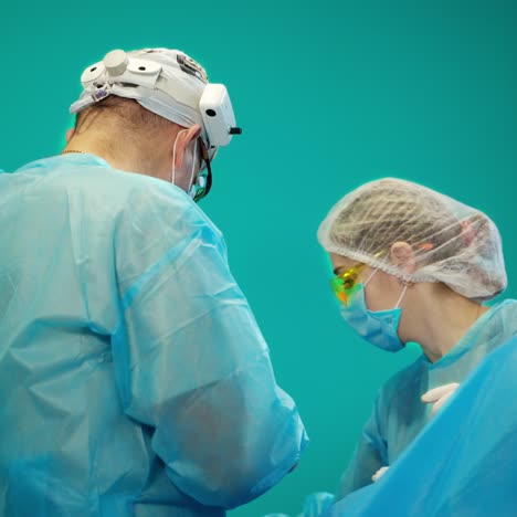 team of surgeons doing plastic surgery in modern clinic. group of medical workers in blue uniform perform an operation to a patient.