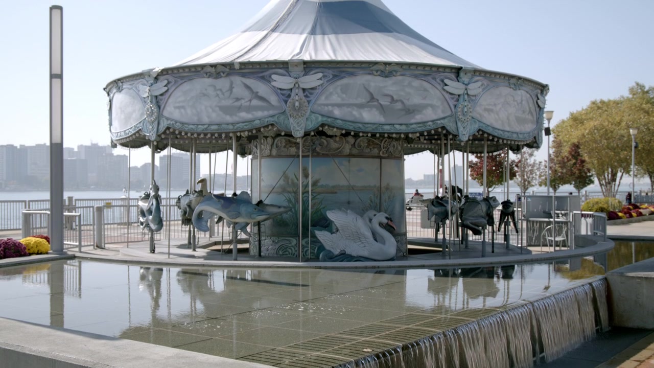 Carousel in downtown Detroit, Michigan with video tilting up in slow motion.