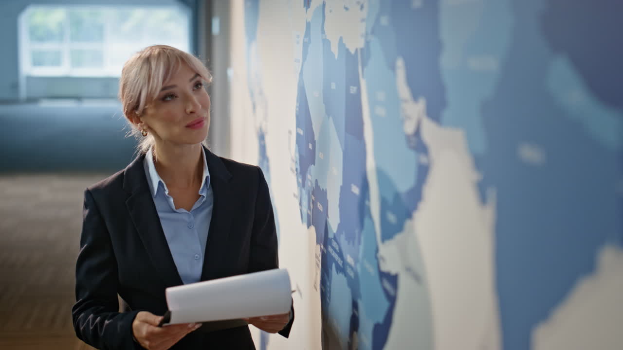 Inspired marketer looking world map modern office closeup. Businesswoman working