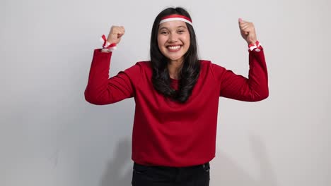 young asian woman happy confidence showing strong gesture isolated over white background. indonesia independence day concept