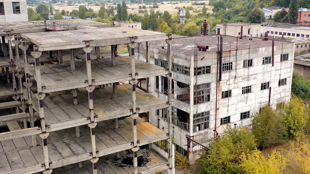 Empty unfinished industrial building. Exterior of abandoned building of an old factory without windows. Ruined architecture after war times.