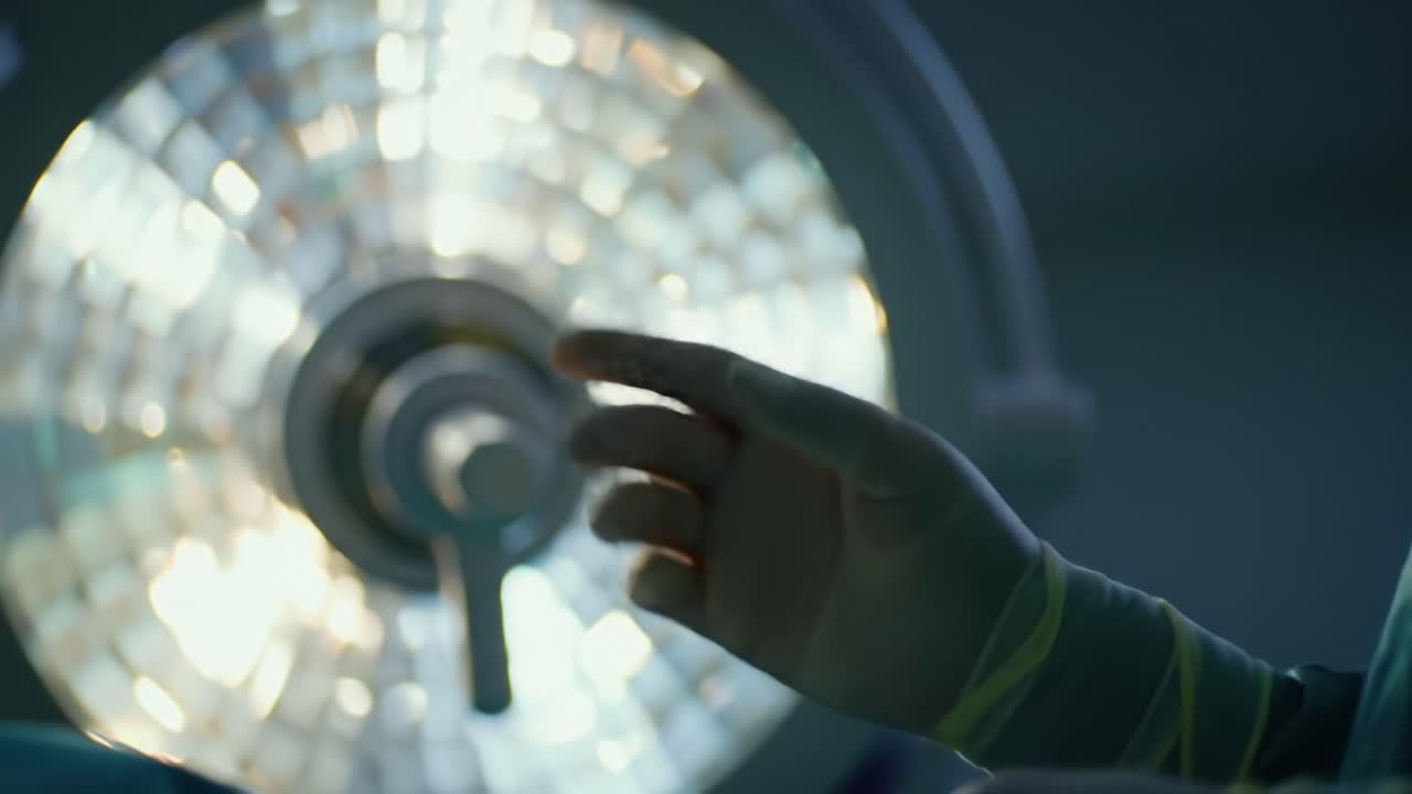 A surgeon prepares for a critical procedure, dressed in surgical attire and under intense overhead lights, showcasing a focused environment for patient care.