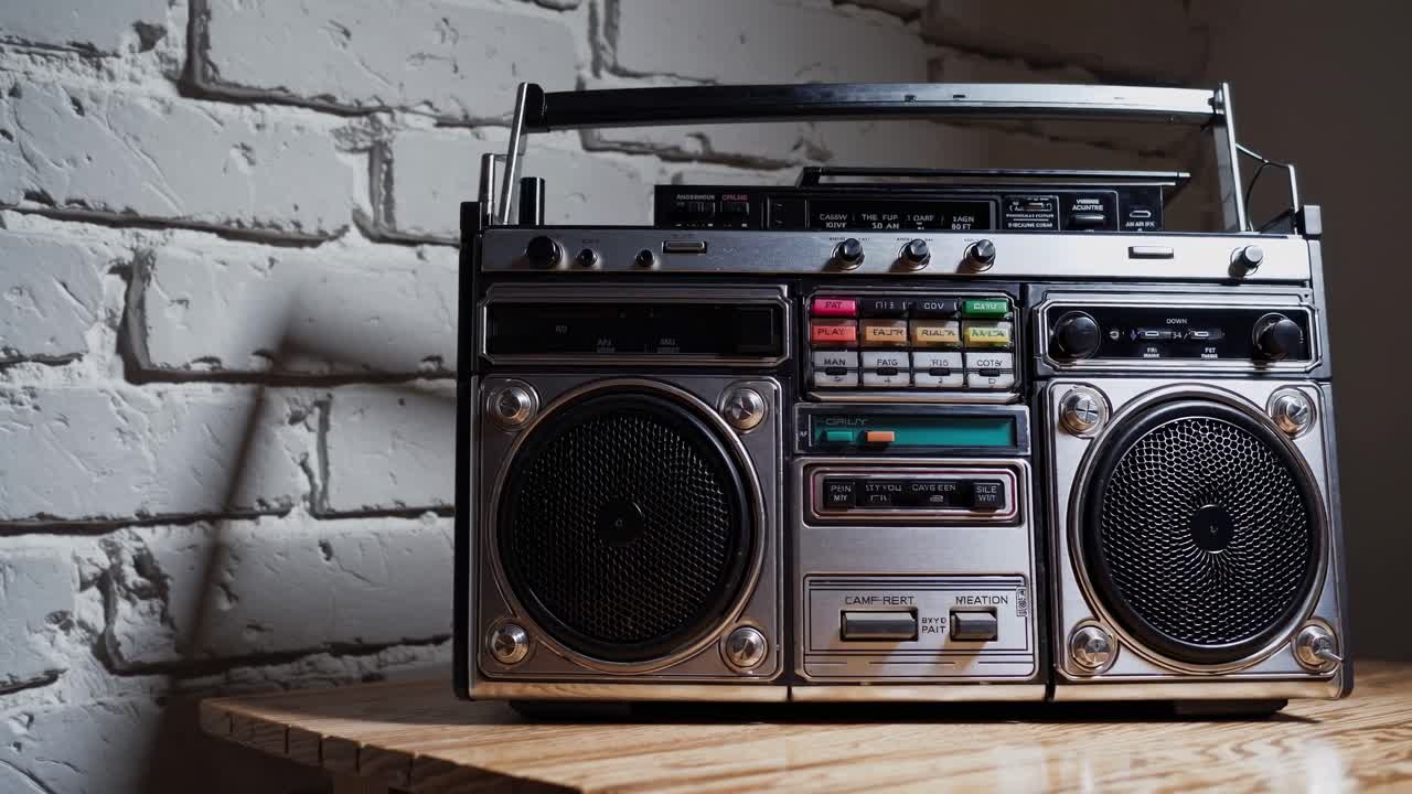 Boombox retrò su un tavolo di legno contro un muro di mattoni bianchi. Un'inquadratura dal basso crea un'atmosfera nostalgica