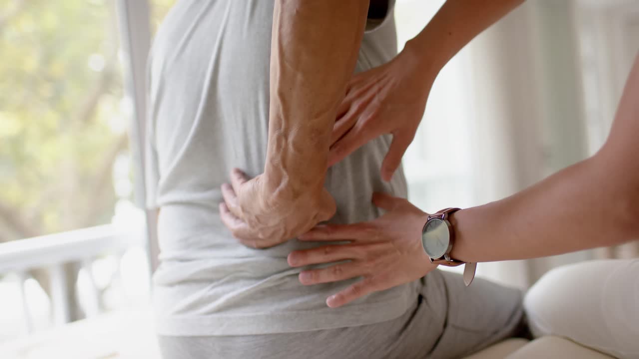 fisioterapeuta masculino diverso examinando a un paciente masculino anciano, en cámara lenta