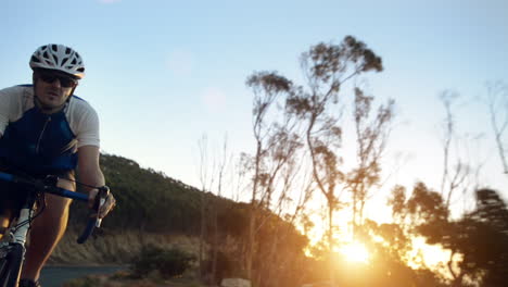 man cycling at sunset on a mountain road