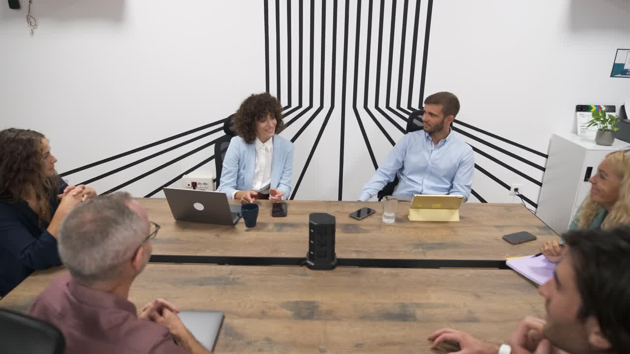 Confident businesswoman discussing strategy with colleagues during conference meeting