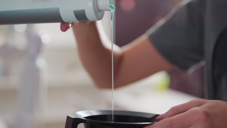 precise hair coloring process, professional stylist prepares color mixture precisely, closeup of professional stylist meticulously measuring and pouring hair coloring solution for precise application